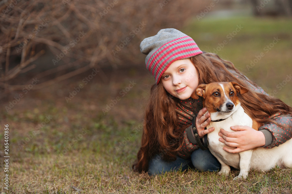 Little girl hugging her friend a dog in outdoors.