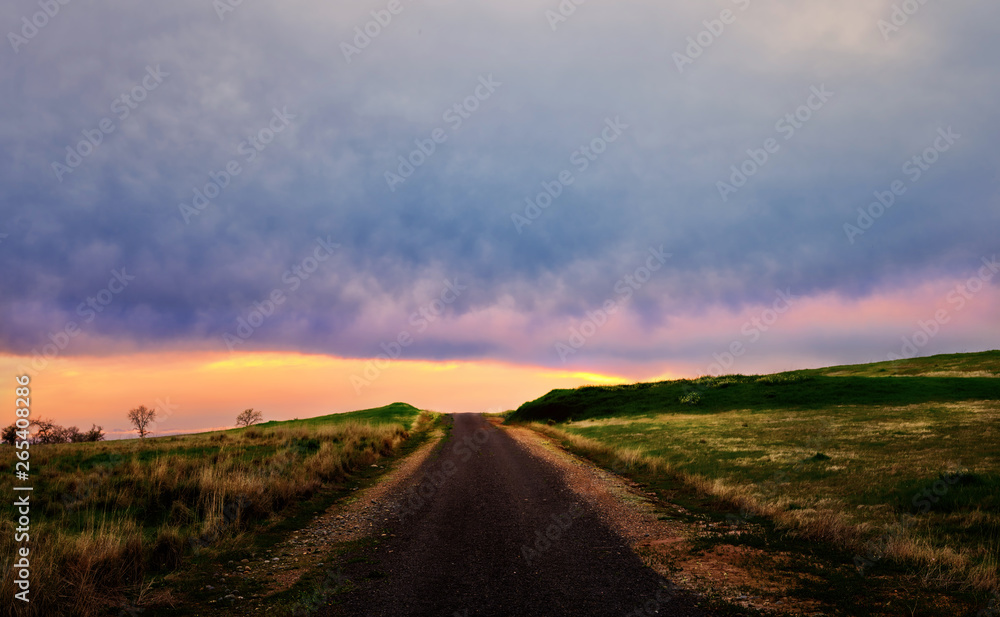 Rural dirt road in the countryside at sunset