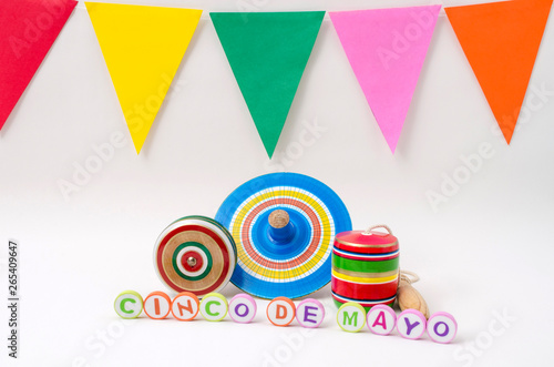 Cinco de mayo made from colorful letters, yo-yo, spinning and balero, wooden mexican toys and colorful flags on white background