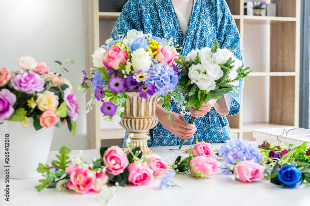 young women business owner florist making or Arranging Artificial flowers vest in her shop, craft and hand made concept - obrazy, fototapety, plakaty 