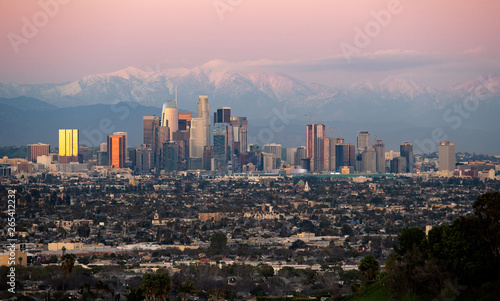 Panoramic view of the city of Los Angeles California with snowy mountain caps showing the end of the drought due to climate change.  The wide view shows Hollywood and Downtown. photo