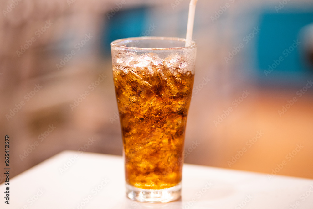 A glass of cola with ice on white table A glass of cola with ice on white table