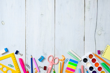 Back to school concept, border frame of colorful stationery supplies for teaching kids drawing on empty white wooden desk. Creative education setting, kids desk top view, flat lay, copy space