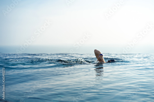 A man swimming for exercise in at swimming pool