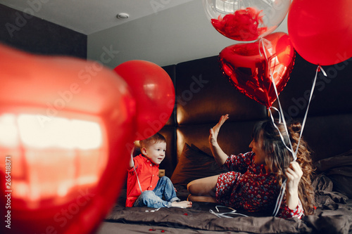 Pregnant woman at home. Mother with son in a bed. Family in a room with decorstions for Valentine's day photo