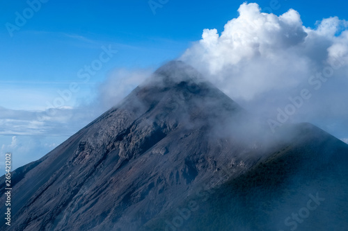Erupting volcano in Guatemala against the blue sky