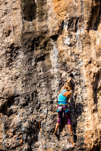 A girl climbs a rock.