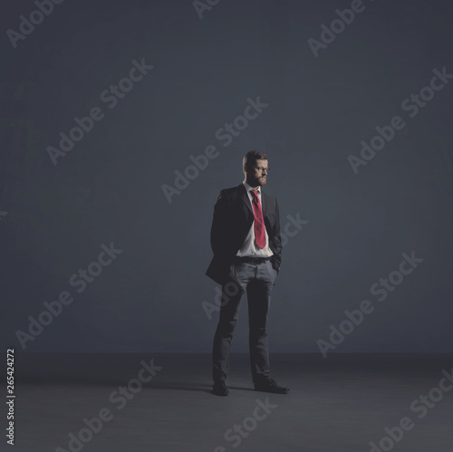 Businessman in formalwear over dark background. Business, finance, career and office concept.