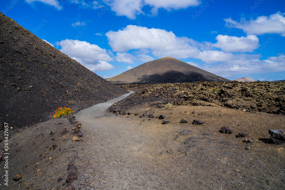 Spain, Lanzarote, Hiking the way alongside lava fields and volcano el cuervo