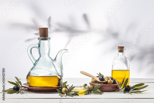 Fototapeta Naklejka Na Ścianę i Meble -  Olive oil and olive branch on the wooden table