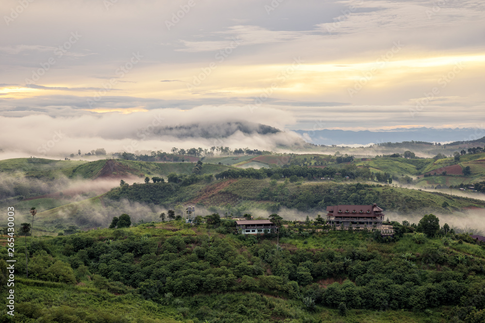 White Mist with early sunrise over the hill and Bungalow in rainy season of Thailand White Mist with early sunrise over the hill and Bungalow in rainy season of Thailand