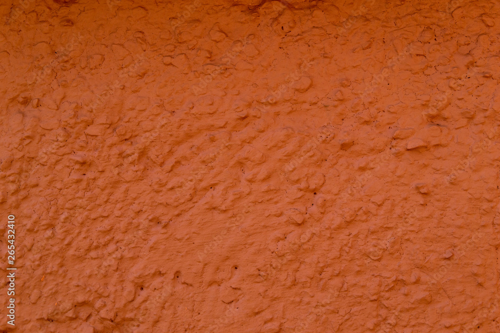 The texture of the concrete wall is coral color. A raw plaster wall background