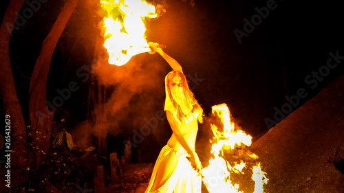 Fire woman posing with burning pair of swords