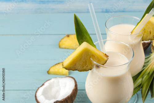 Cocktail Pina Colada. Pina Colada refreshing summer alcoholic cocktail with coconut milk and pineapple juice nearby. summer drink. cocktail preparation. on blue wooden background.
