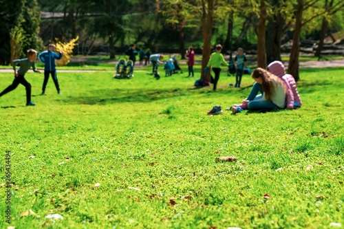 Vibrant background of people in park. Spring and summer season. Selective focus