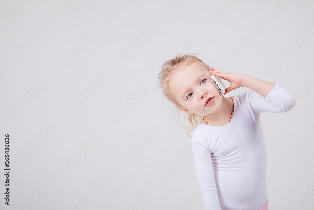 Portrait of the little girl's positive that talking on a cell phone, isolated on white background. Portrait of the little girl's positive that talking on a cell phone, isolated on white background.
