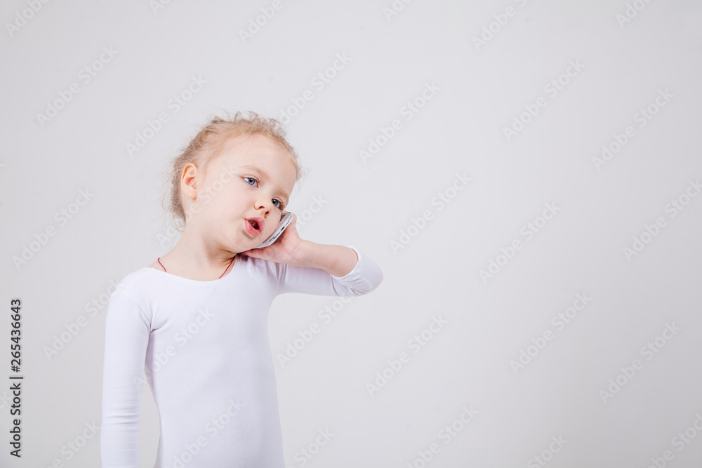 Portrait of the little girl's positive that talking on a cell phone, isolated on white background. Portrait of the little girl's positive that talking on a cell phone, isolated on white background.