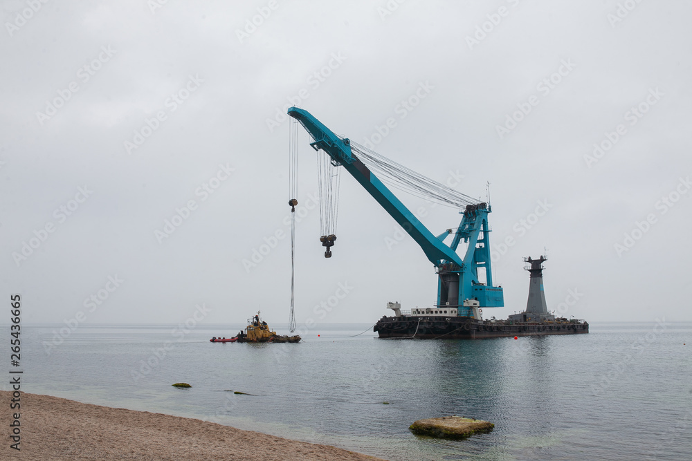 Fototapeta premium a large floating crane saves a barge aground in Odessa