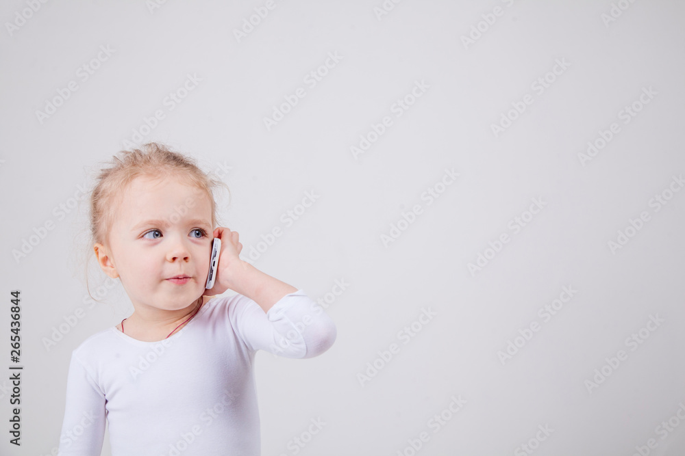 Portrait of the little girl's positive that talking on a cell phone, isolated on white background. Portrait of the little girl's positive that talking on a cell phone, isolated on white background.