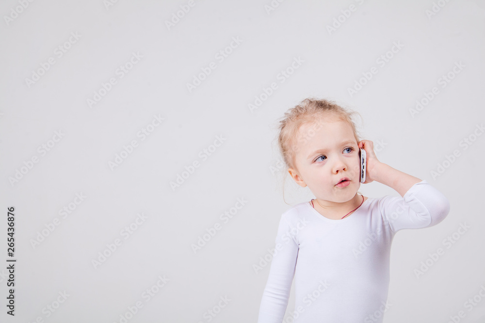 Portrait of the little girl's positive that talking on a cell phone, isolated on white background. Portrait of the little girl's positive that talking on a cell phone, isolated on white background.