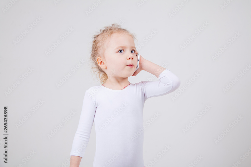 Portrait of the little girl's positive that talking on a cell phone, isolated on white background. Portrait of the little girl's positive that talking on a cell phone, isolated on white background.
