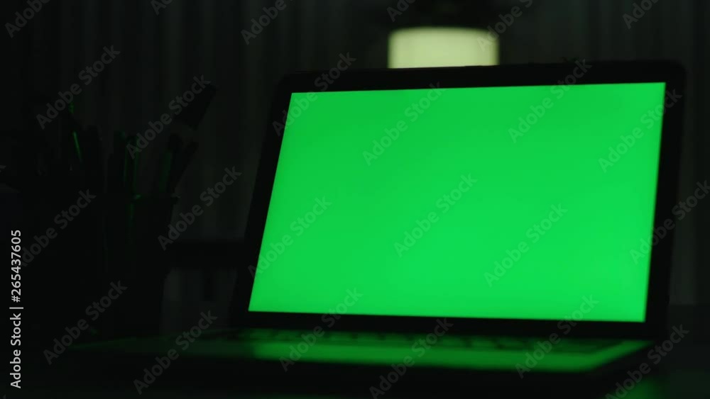 Laptop with green screen. Dark office. Perfect to put your own image or video.Green screen of technology being used. Chroma Key laptop Laptop with green screen. Dark office. Perfect to put your own image or video.Green screen of technology being used. Chroma Key laptop