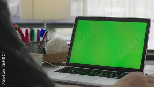 Woman working at home on with laptop green screen