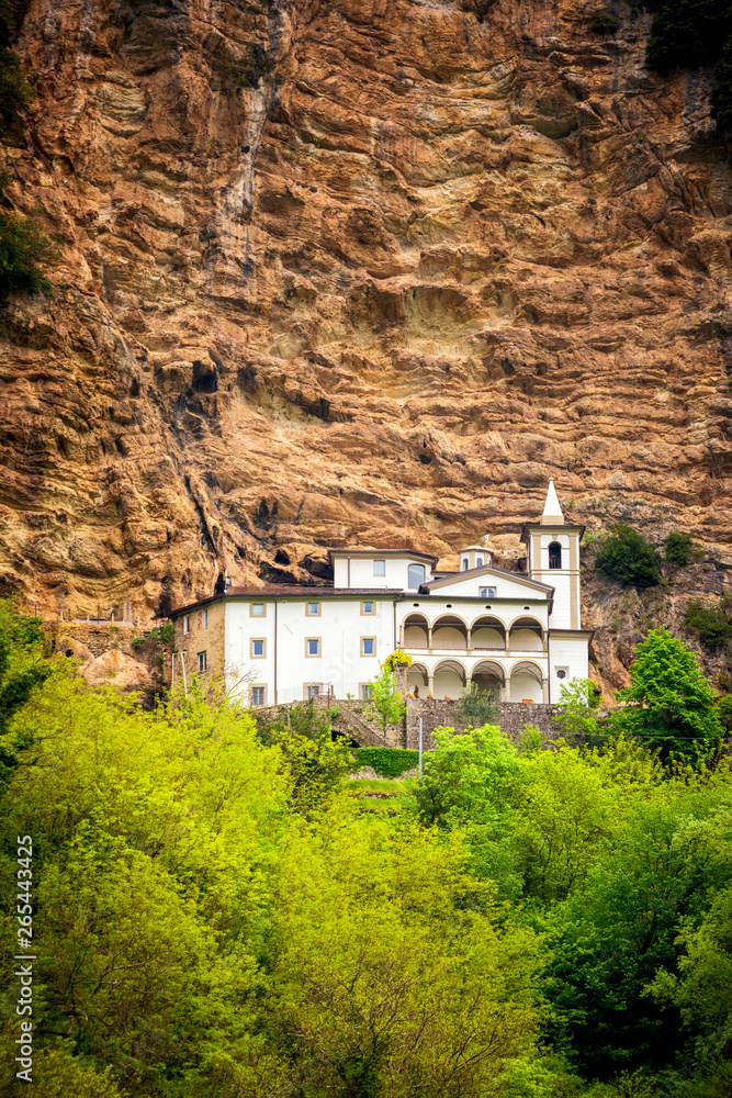 View of the beautiful Hermitage of Calomini (Eremo di Calomini), placed in a spectacular position, at the base of a sheer limestone wall. Vergemoli, Lucca, Garfagnana, Tuscany, Italy