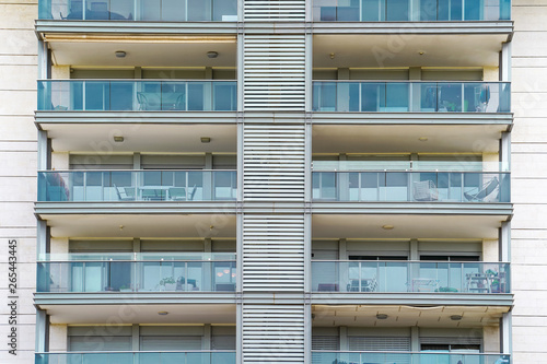 Glass blue Windows of modern city business building skyscraper. Glass balconies in the building. Modern apartment buildings in new neighborhood. Windows of a building, texture.