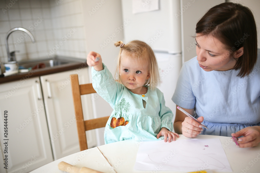 Mom and cute blonde girl in dresses paint together Mom and cute blonde girl in dresses paint together