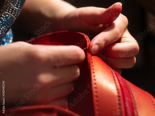 Leather workshop Hands of the girl Red leather