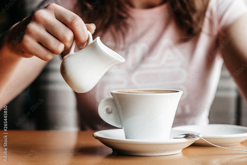 Morning coffee. Closeup of women's hands with coffee cup in a cafe. Female hands holding cups of coffee on a wooden table background in a cafe, vintage color tone Morning coffee. Closeup of women's hands with coffee cup in a cafe. Female hands holding cups of coffee on a wooden table background in a cafe, vintage color tone