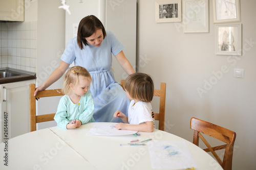Mom paint with children at table in real kitchen