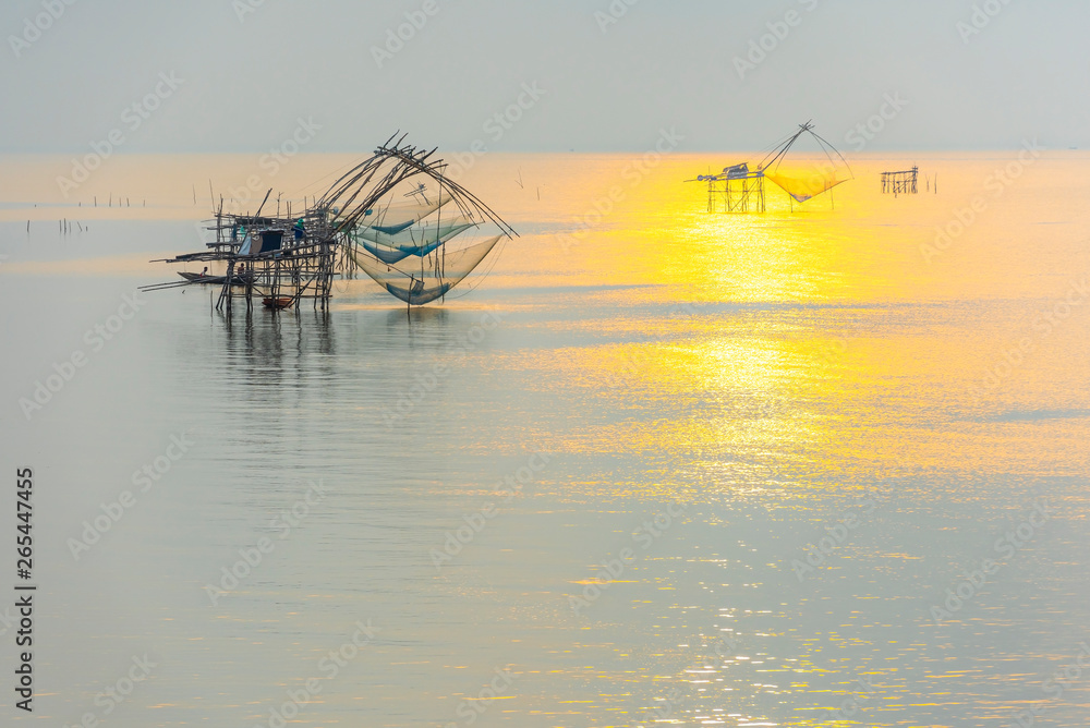 Tourists on the long tail boat at sunrise, net fishing of fishermen, Pakpra, Phatthalung, Thailand.