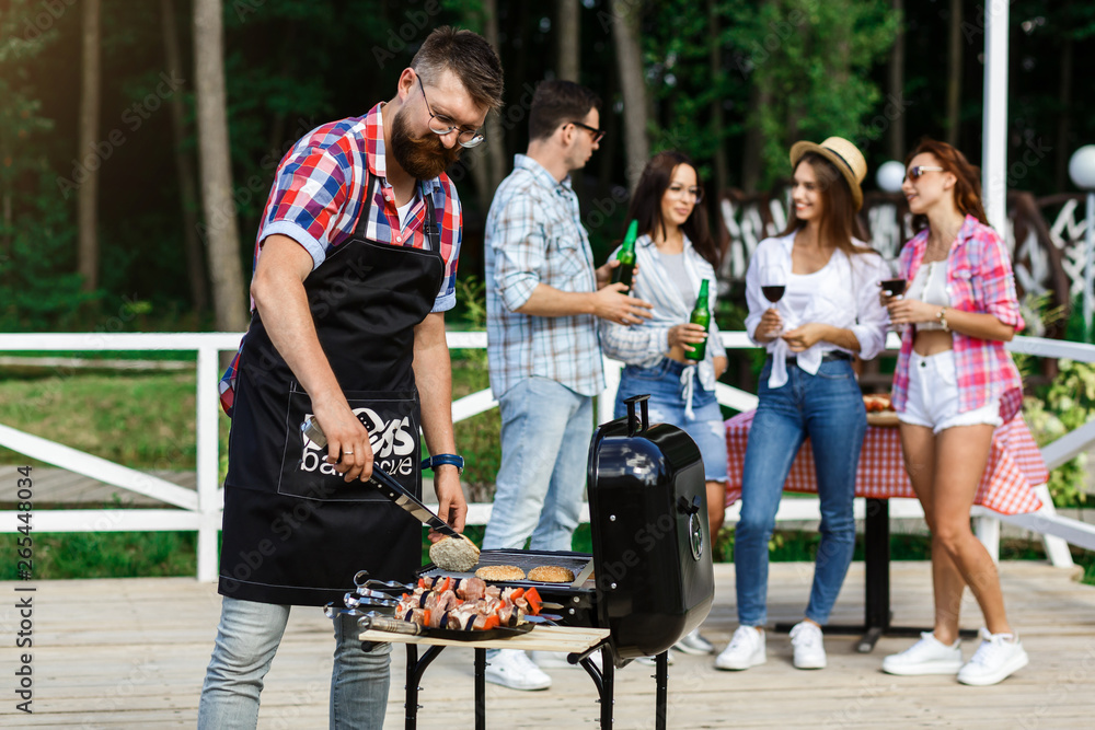 Obraz premium Small group of friends drink alcohol and having a meal at barbecue party. Diverse People Friends Hanging Out Drinking Concept