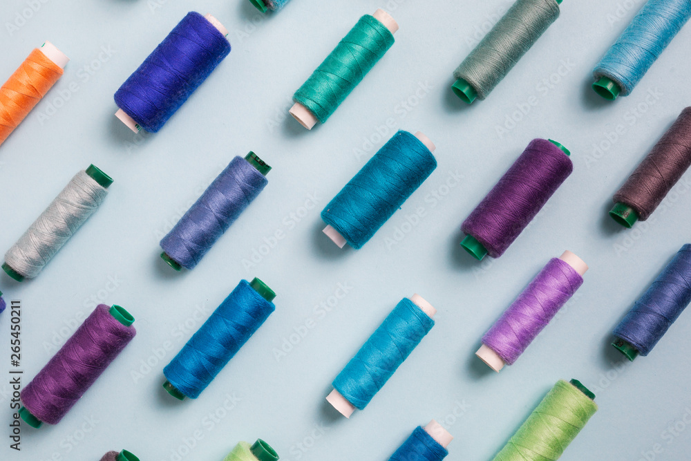 Flat lay composition with sewing threads on blue background Flat lay composition with sewing threads on blue background
