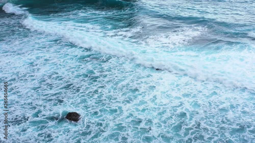Waves and azure water as a background. View from high rock at the ocean surface. Natural summer seascape. Water background. Indonesia - video Waves and azure water as a background. View from high rock at the ocean surface. Natural summer seascape. Water background. Indonesia - video