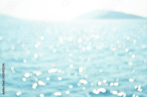 Blurred water background. Sea water surface and waves stretch out to the horizon where islands are visible far away.
