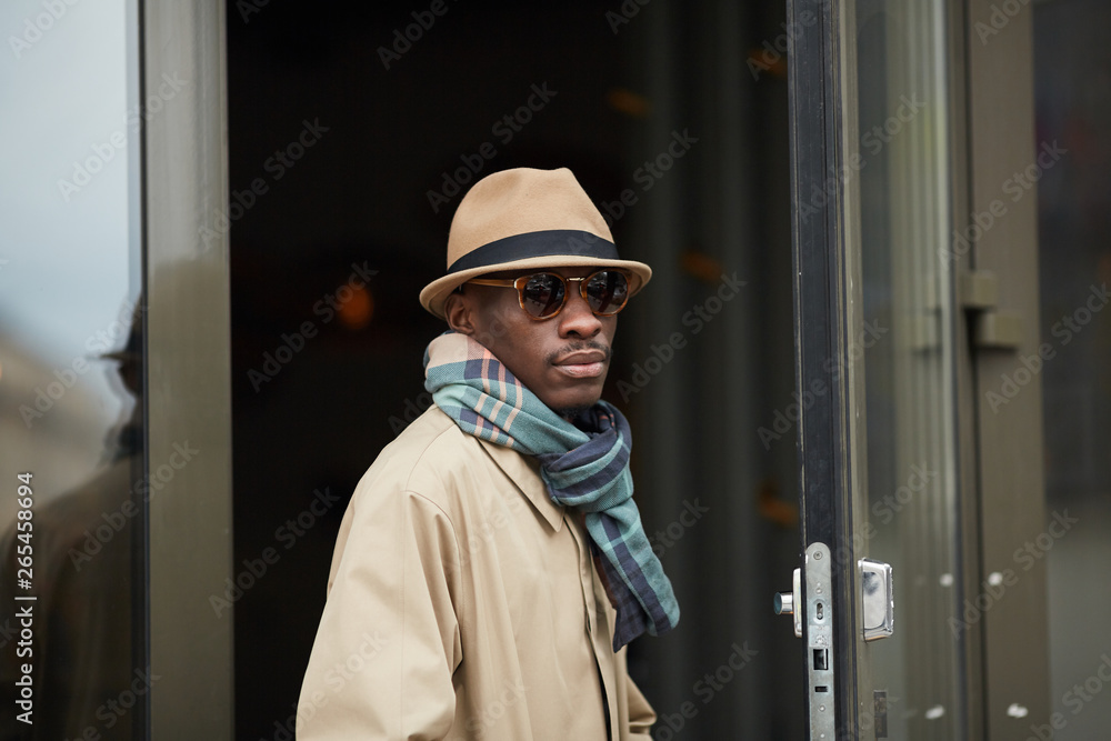 Waist up portrait of modern African-American man wearing hat posing outdoors in city, copy space Waist up portrait of modern African-American man wearing hat posing outdoors in city, copy space