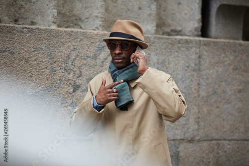 Εκτύπωση καμβά Waist up portrait of modern African-American man wearing trenchcoat speaking by