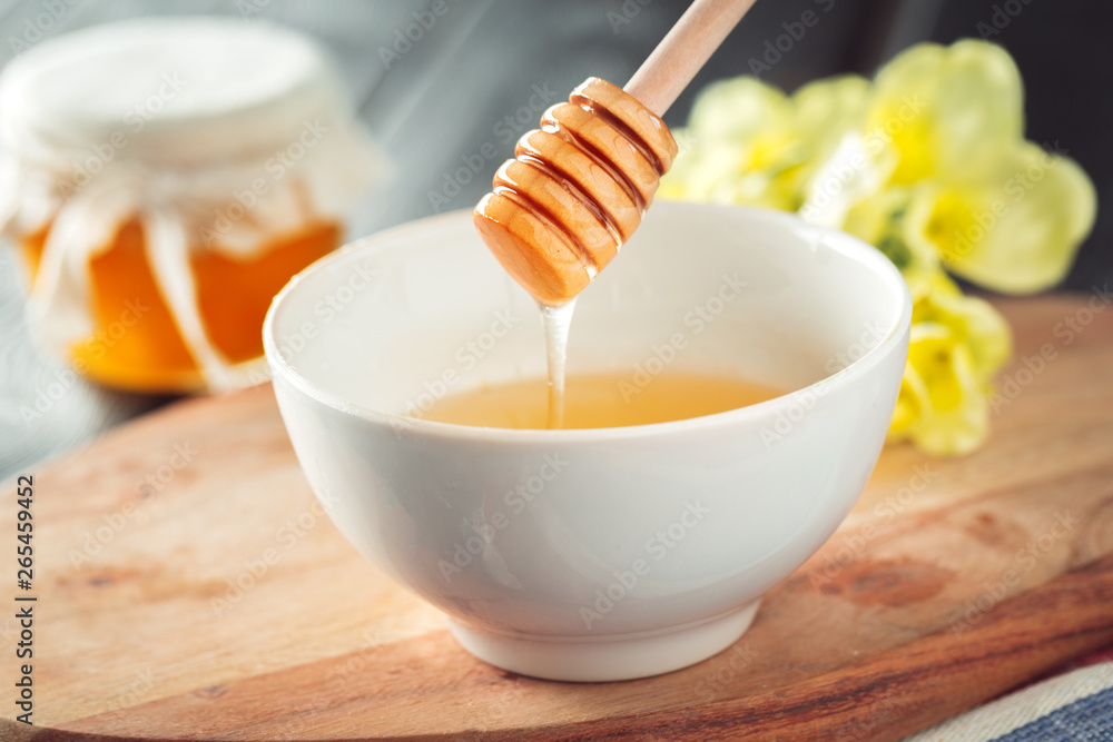 Honey background. Sweet honey in glass jar on wooden background. Honey background. Sweet honey in glass jar on wooden background.