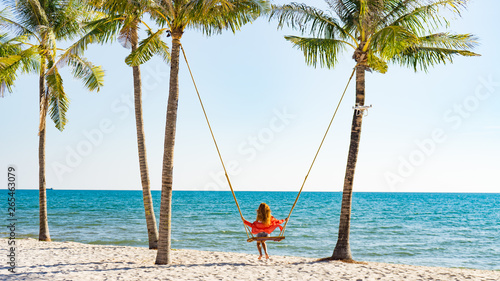 Vacation concept. Young woman swing on a beach swing. Happy traveller women on the Phu Quoc beach