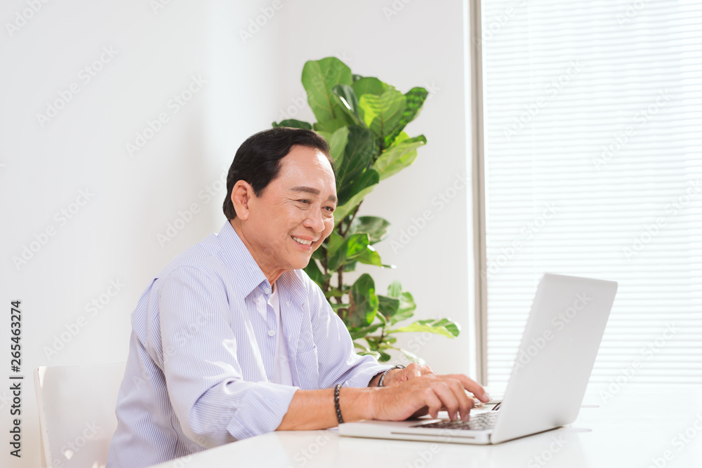 Senior man working with laptop and basic things for work at his desk Senior man working with laptop and basic things for work at his desk