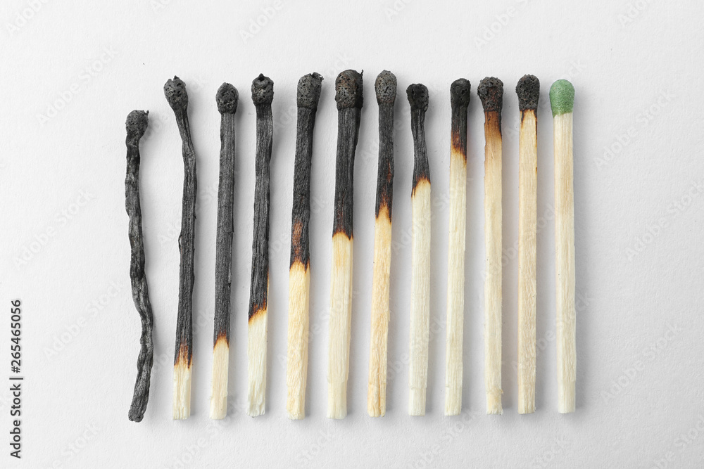 Row of burnt matches and whole one on white background, top view. Human life phases concept Row of burnt matches and whole one on white background, top view. Human life phases concept
