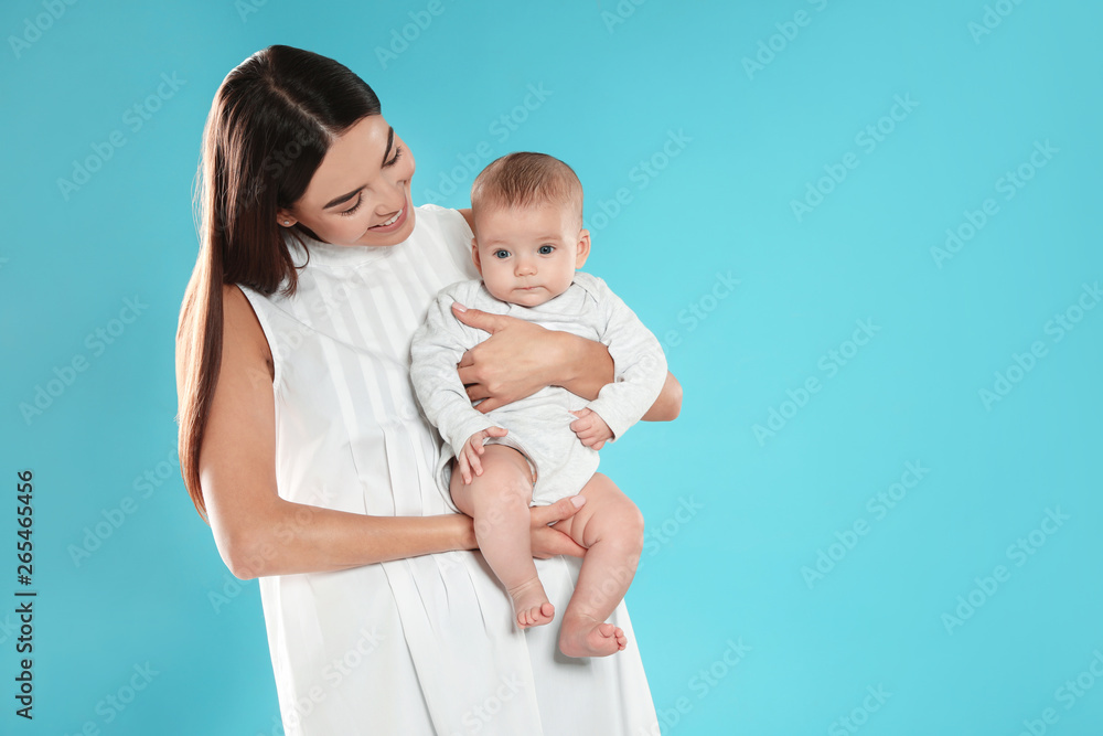 Portrait of happy mother with her baby on color background. Space for text