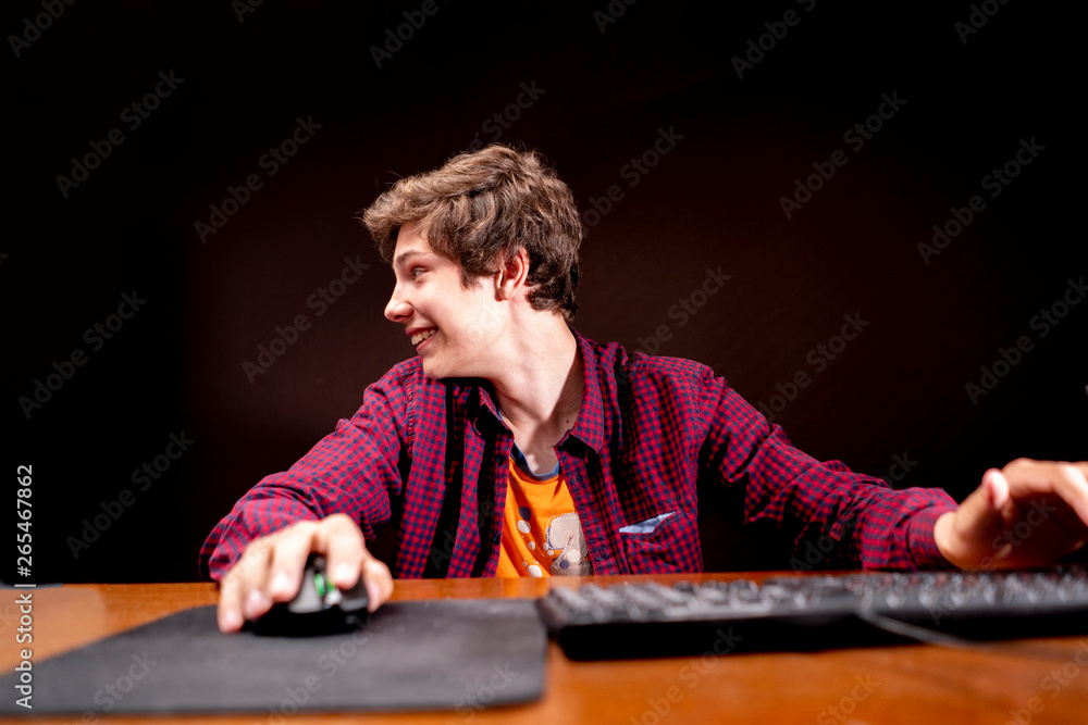 young male playing computer video games on a table in a dark room b young male playing computer video games on a table in a dark room b