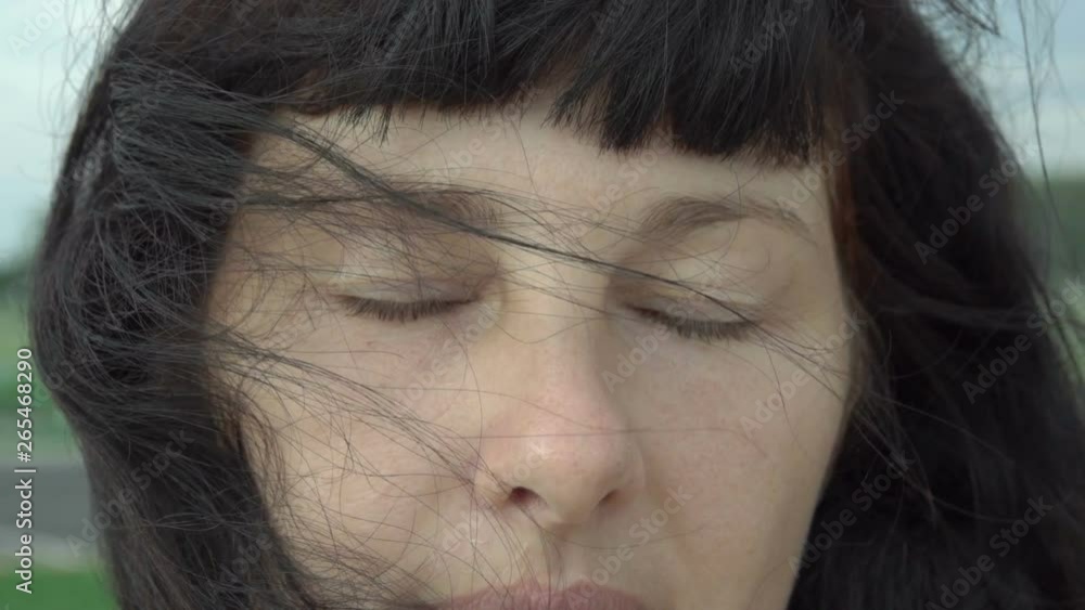 Portrait of beautiful young woman with closed eyes closeup. Wind blowing hair. Slow Motion. Attractive woman brunette confident pretty. Windy weather. Portrait of beautiful young woman with closed eyes closeup. Wind blowing hair. Slow Motion. Attractive woman brunette confident pretty. Windy weather.