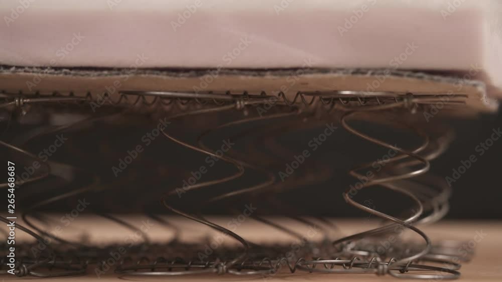 A close-up of an expert worker checking offset coils flexibility. Furniture manufacture concept A close-up of an expert worker checking offset coils flexibility. Furniture manufacture concept