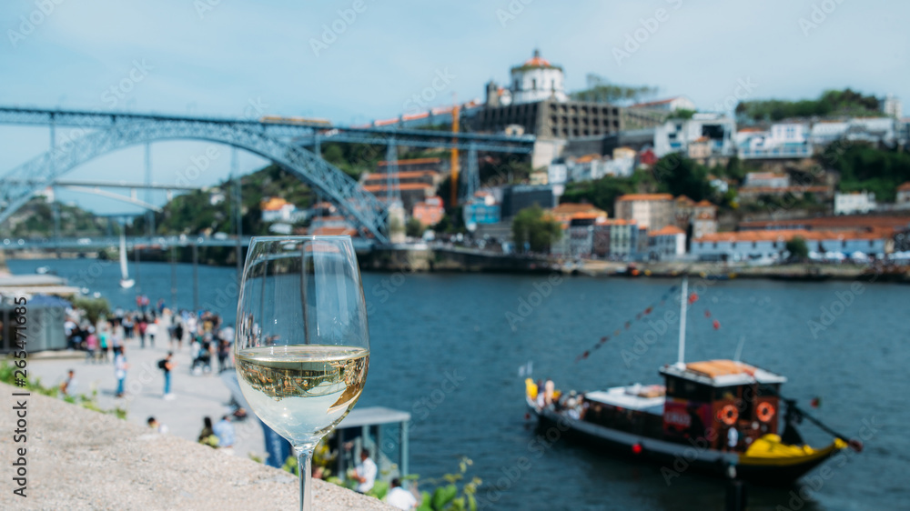 White wine glass overlooking Cais da Ribeira on the River Douro in Porto, Portugal