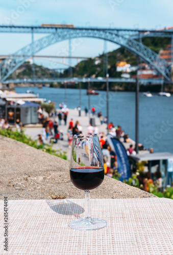 Red wine glass overlooking Cais da Ribeira on the River Douro in Porto, Portugal photo